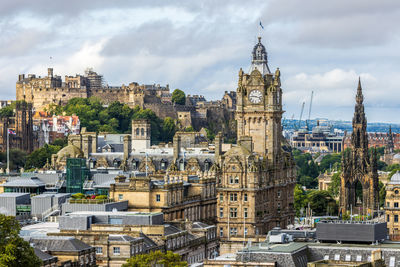 Buildings in city against cloudy sky