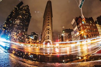 Light trails in city against sky at night