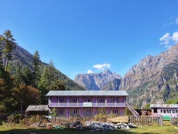 Built structure against trees and mountains against clear sky