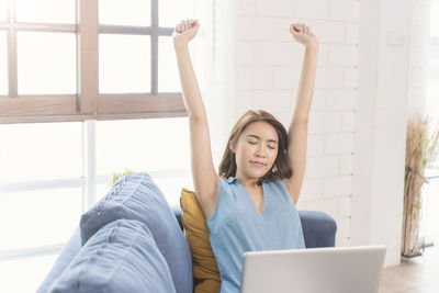 Young woman using mobile phone at home