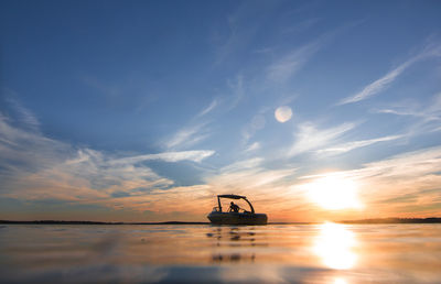 Silhouette ship in sea against sky during sunset