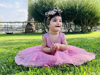 Portrait of cute girl sitting on field