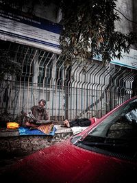 Rear view of man sitting outside temple in building