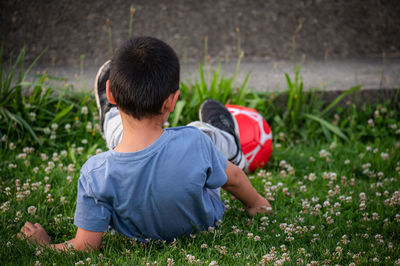 Side view of boy playing with ball on field