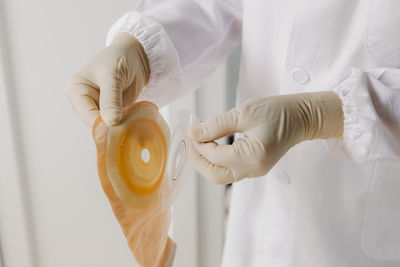 Midsection of doctor holding dentures