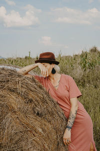 Woman leaning on hay bale