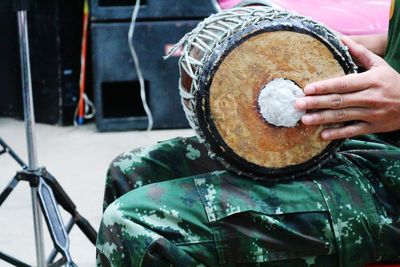 Midsection of man playing drum