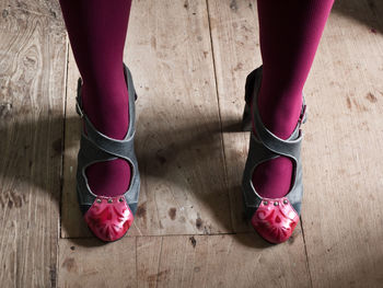 Low section of women standing on hardwood floor