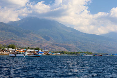 Scenic view of sea and mountains against sky