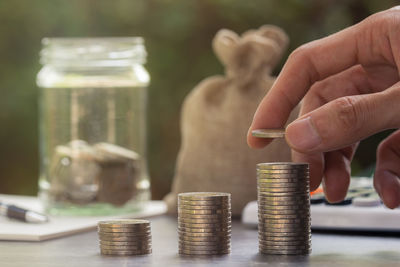 Close-up of hand holding coin stack