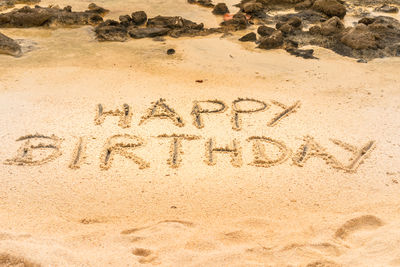 High angle view of text on sand at beach