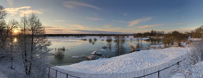 Scenic view of lake against sky during winter