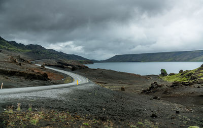 Scenic view of road leading towards mountains against sky