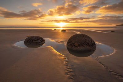 Scenic view of beach against sky during sunset