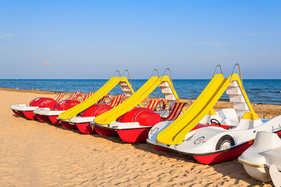 Multi colored umbrellas on beach against sky