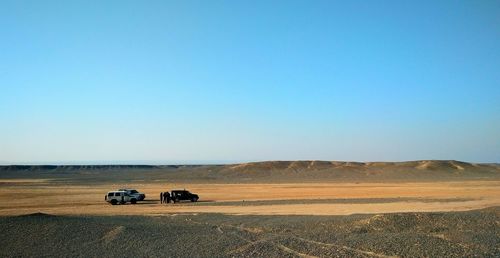 Scenic view of desert against clear blue sky