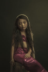 Portrait of a girl wearing hat against black background