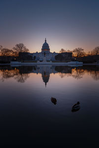 Reflection of building in lake at sunset