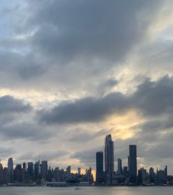 Buildings in city against cloudy sky