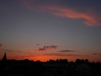 Silhouette landscape against dramatic sky during sunset