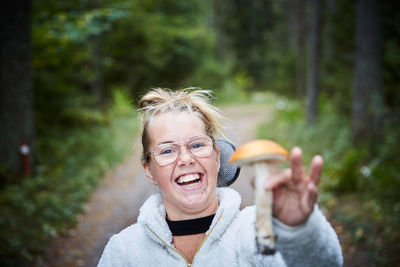 Portrait of disabled young woman holding mushroom in forest