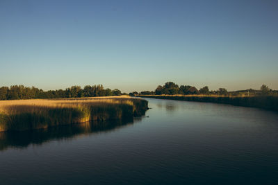 Scenic view of lake against clear blue sky