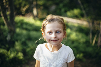 Portrait of smiling girl standing in forest