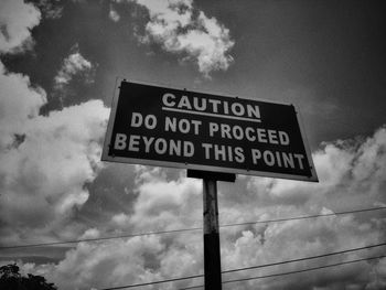 Low angle view of road sign against sky