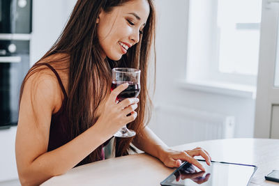 Young woman using mobile phone at home