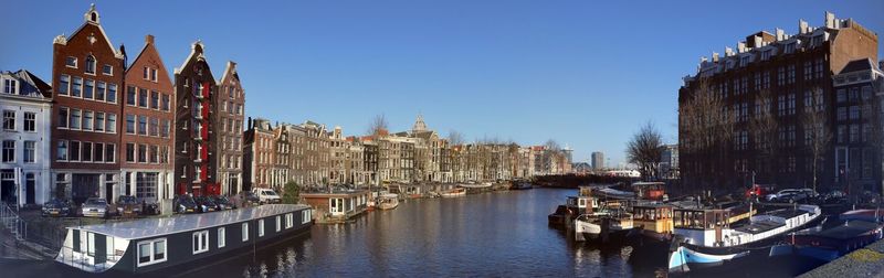 Panoramic view of canal amidst city against clear sky