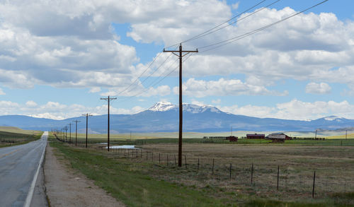 Road amidst field against sky