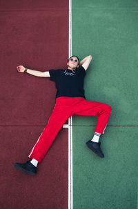 High angle view of young woman lying on playing field