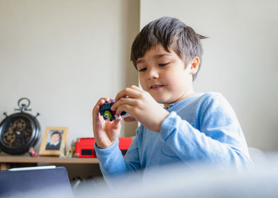 Portrait of boy holding camera at home