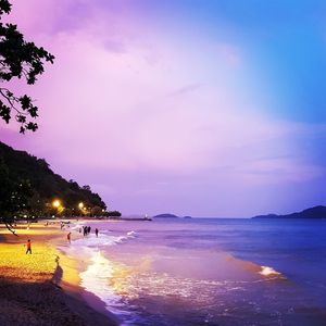 Scenic view of beach against sky at sunset
