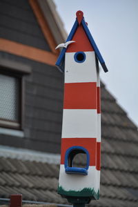 Low angle view of birdhouse against house