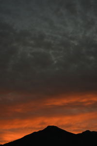 Scenic view of dramatic sky over silhouette landscape