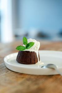 Chocolate fondant with vanilla ice cream on a white plate.