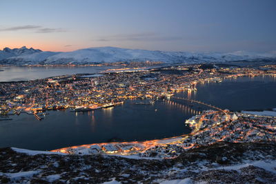 Aerial view of cityscape and mountains against sky during sunset