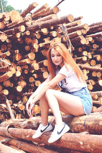 Portrait of young woman sitting on wood