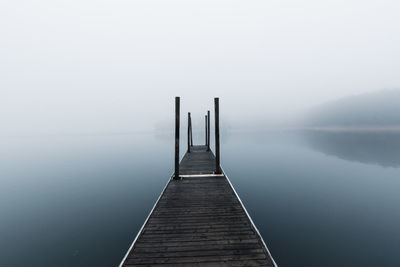 Pier over lake against sky