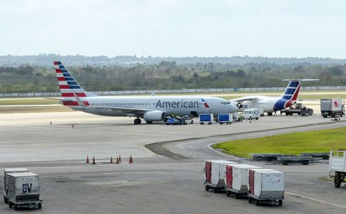 Airplane on airport runway against sky