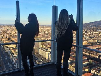People standing by cityscape against sky