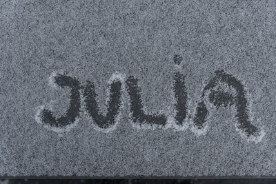 Close-up of text on sand