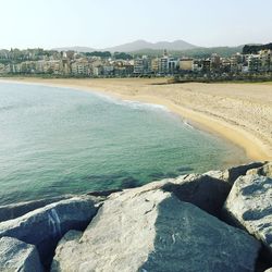 Scenic view of sea and cityscape against sky