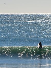 Silhouette man in sea against clear sky