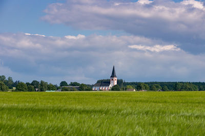 Building on field against sky