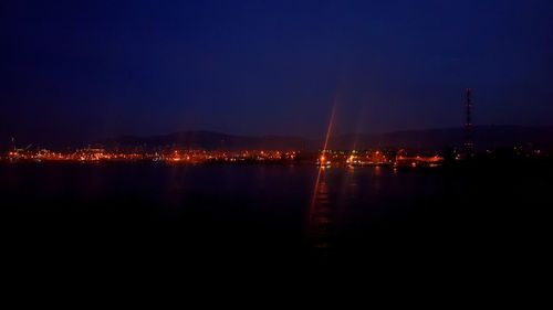 Illuminated city against clear sky at night