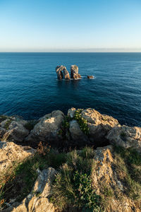 Scenic view of rocks in sea against sky