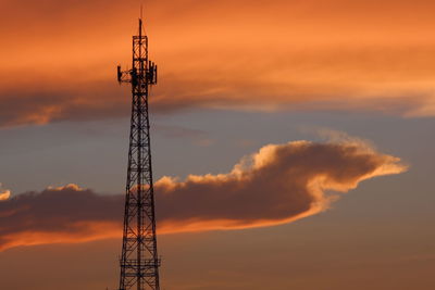 Low angle view of communications tower against sky during sunset