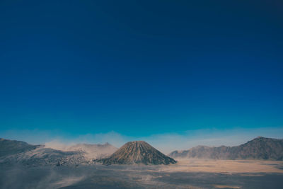 Scenic view of desert against clear blue sky